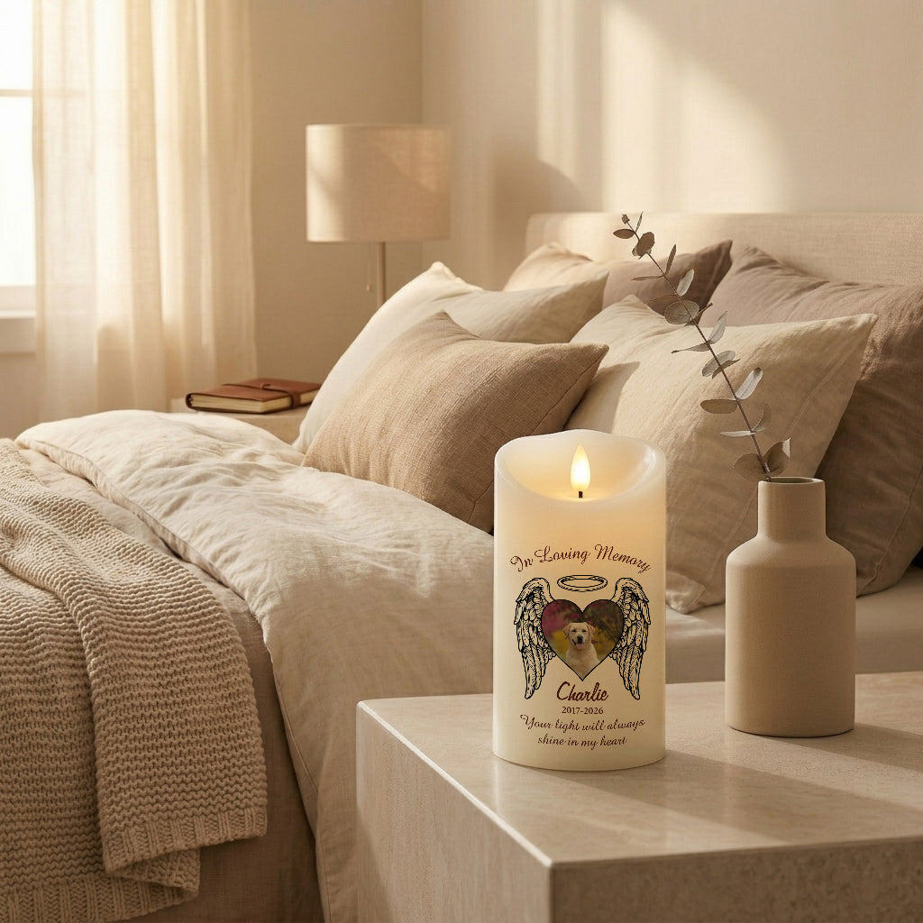 Personalized heart wings pet memorial candle lit on a shelf alongside other keepsakes