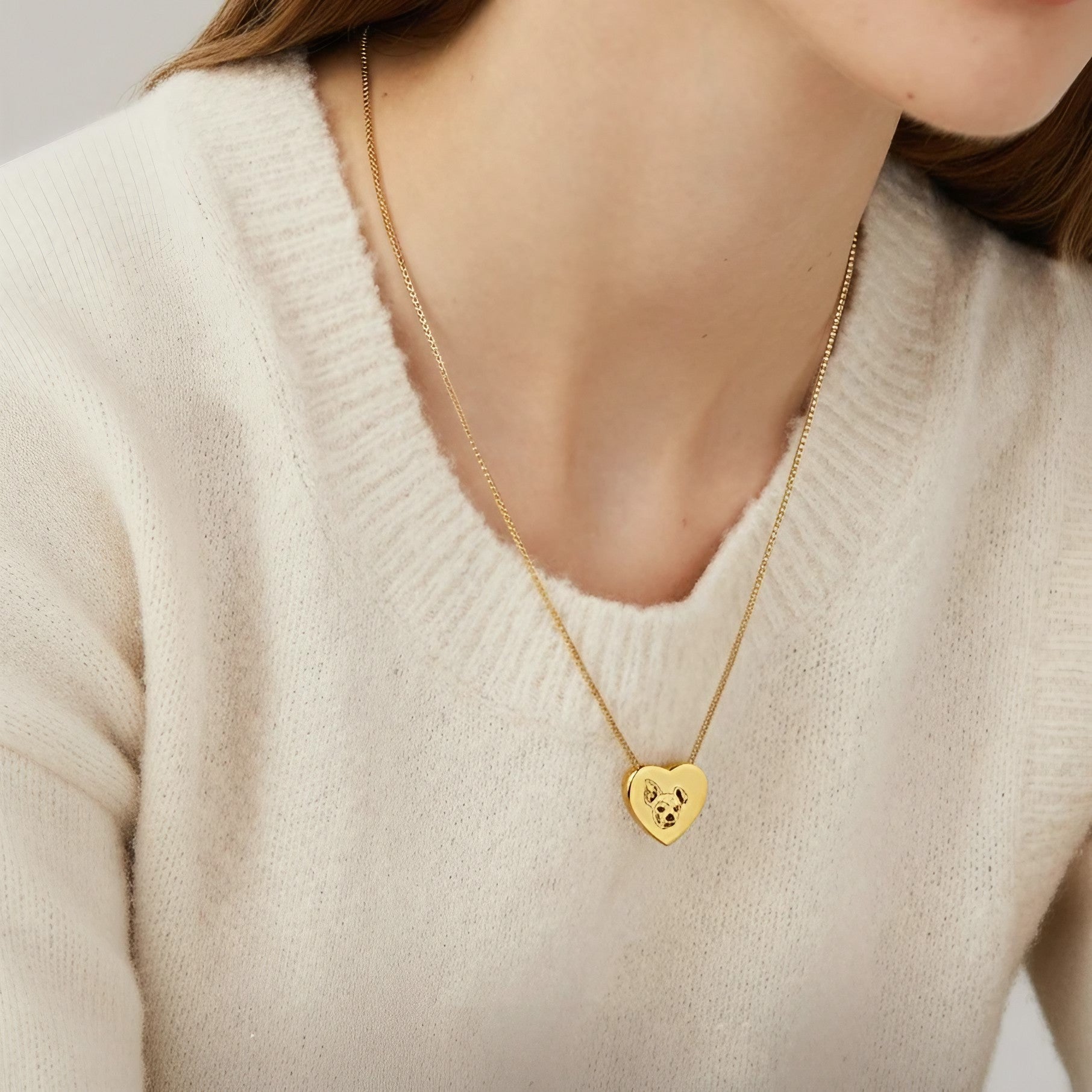Person wearing a heart pendant necklace with a custom pet portrait as a memorial keepsake