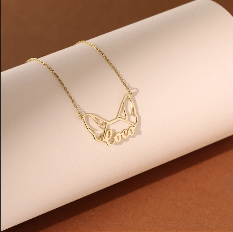 Close-up of engraved pet name on a minimal ear-outline pendant necklace in rose gold