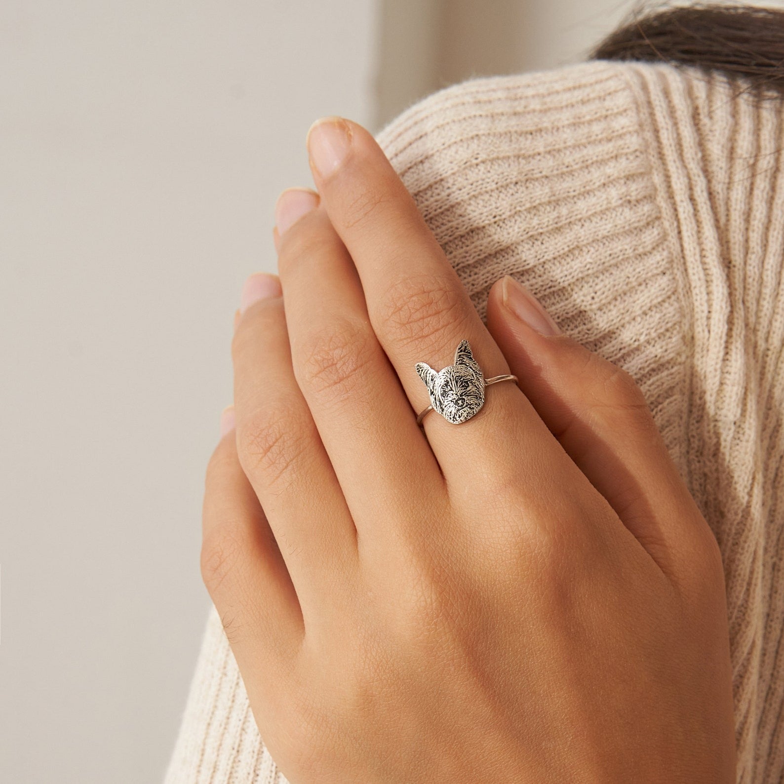Person wearing a slim custom pet portrait ring with engraved pet face as a personalized gift