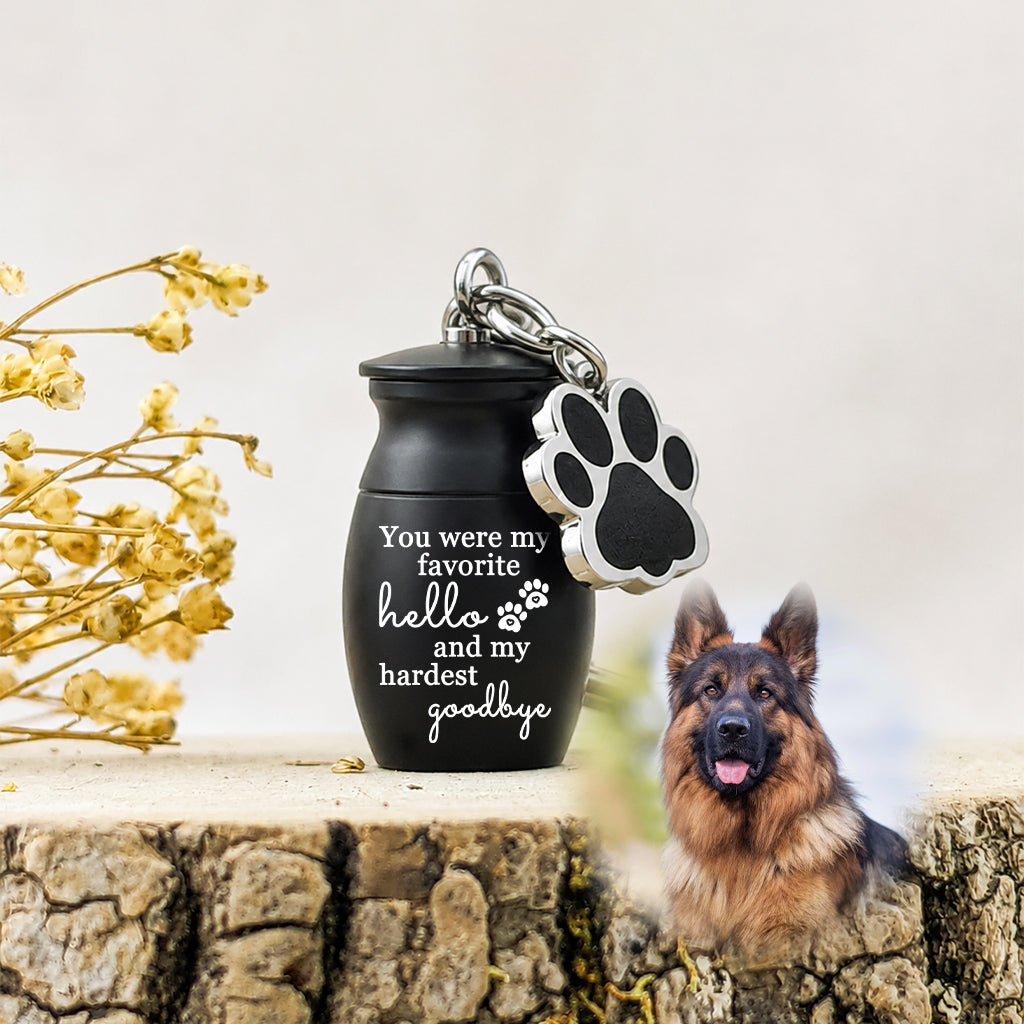 Close-up of custom engraving on a small pet urn keychain showing name and memorial message
