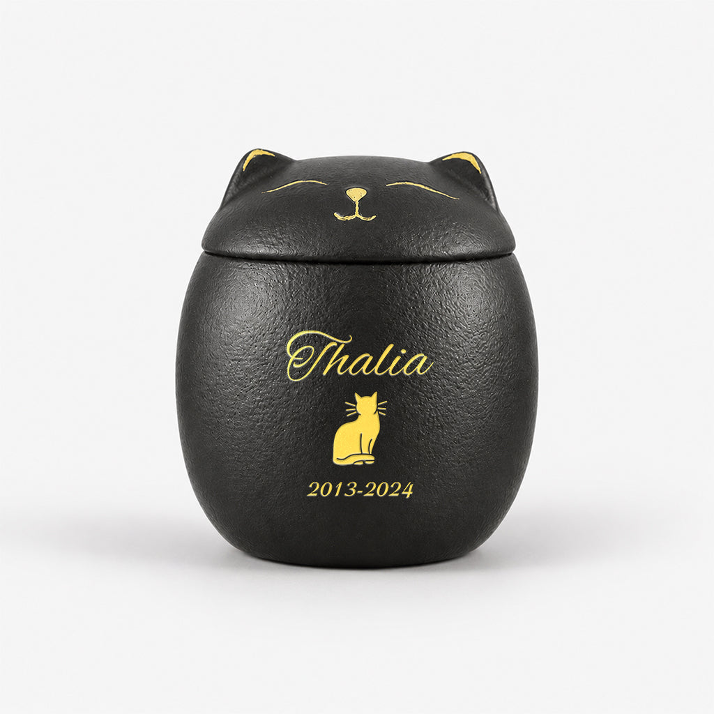 Cat-shaped ceramic urn with lid removed showing interior capacity for holding pet ashes