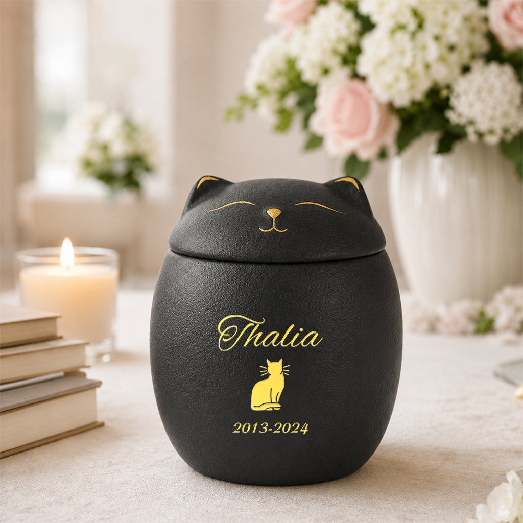 Ceramic cat-shaped cremation urn in black finish with personalized name printed on the body