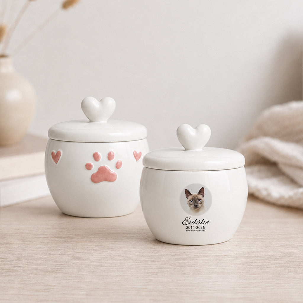 White ceramic cat cremation urn with circular photo window, paw print motif, and personalized name