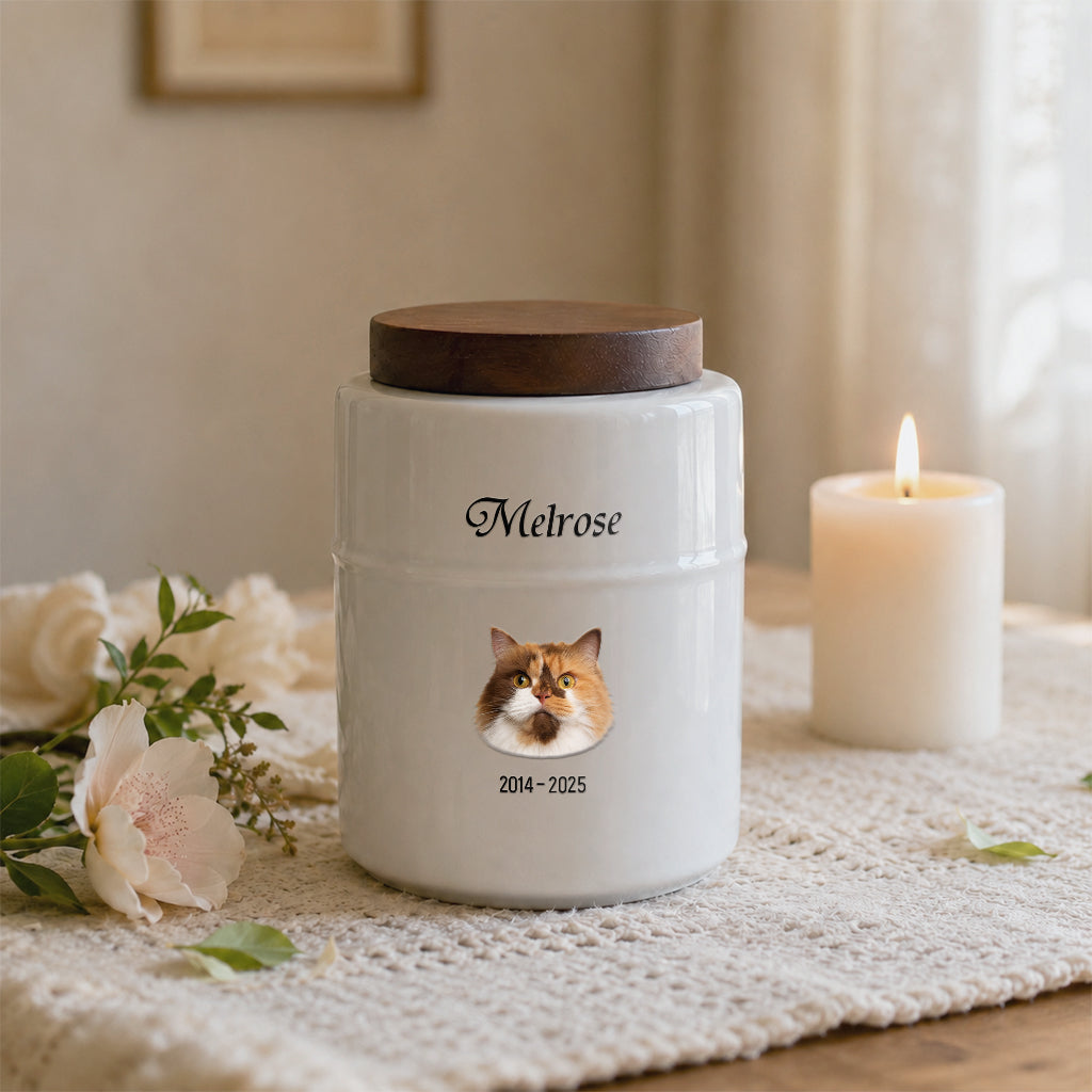 Side view of white cylindrical cat memorial urn showing wood lid and smooth ceramic body