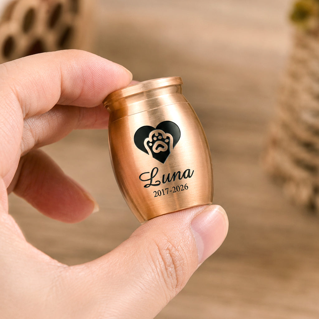 Mini pet cremation urn held in a person's palm showing its compact keepsake size