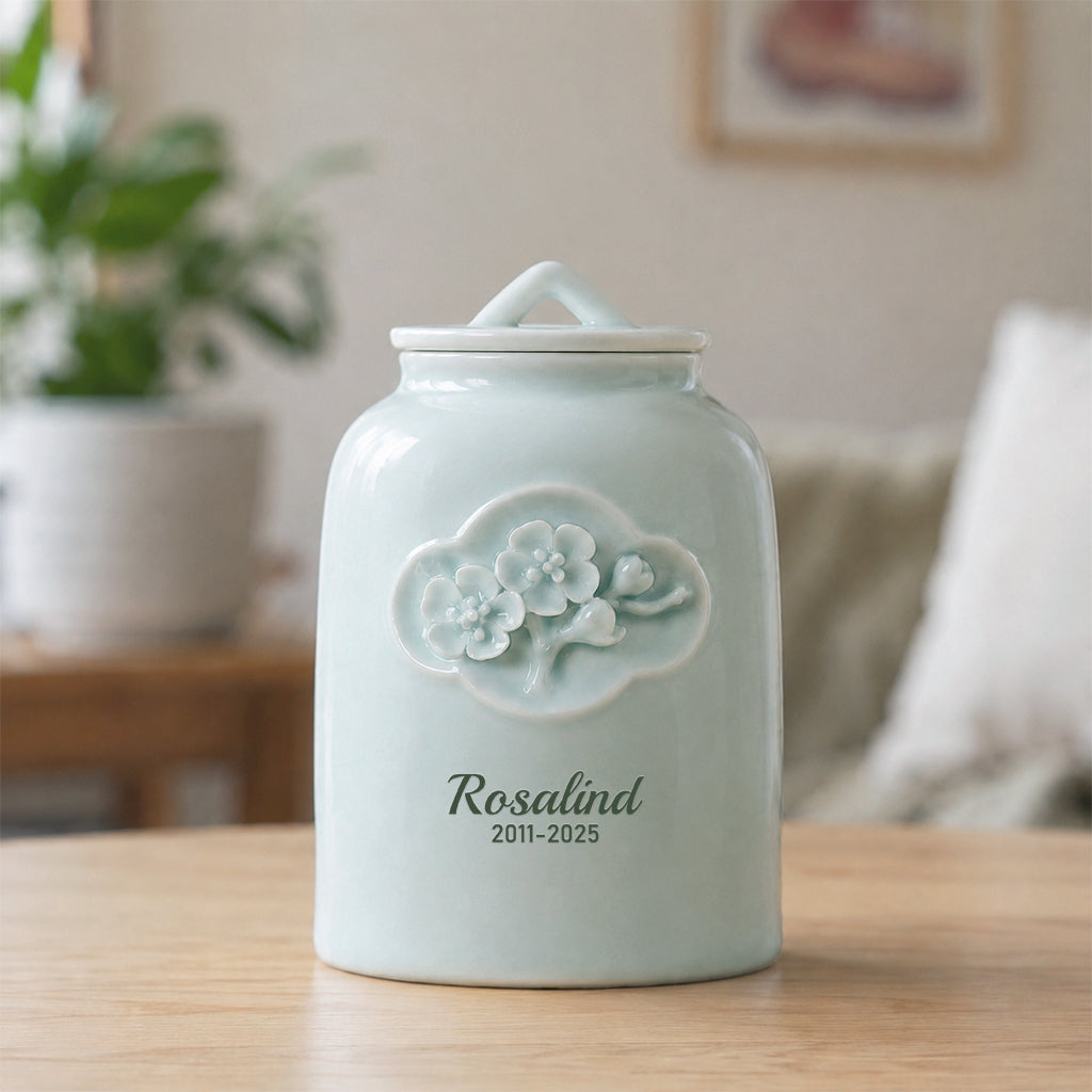 Celadon ceramic pet cremation urn with raised floral relief design and personalized pet name