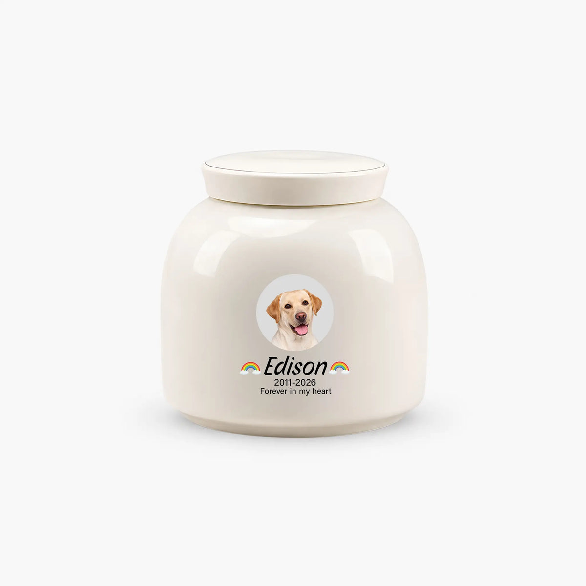 Cream ceramic dog cremation urn with a round pet photo, rainbows beside the name, dates and memorial line