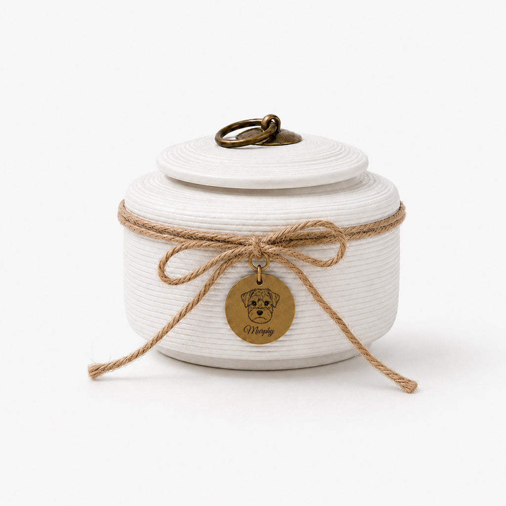 Dog cremation urn with charm tag displayed as a dog loss memorial gift on a wooden surface