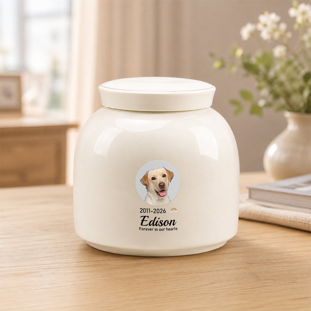 Side view of round ceramic dog memorial urn showing smooth cream finish and photo print placement