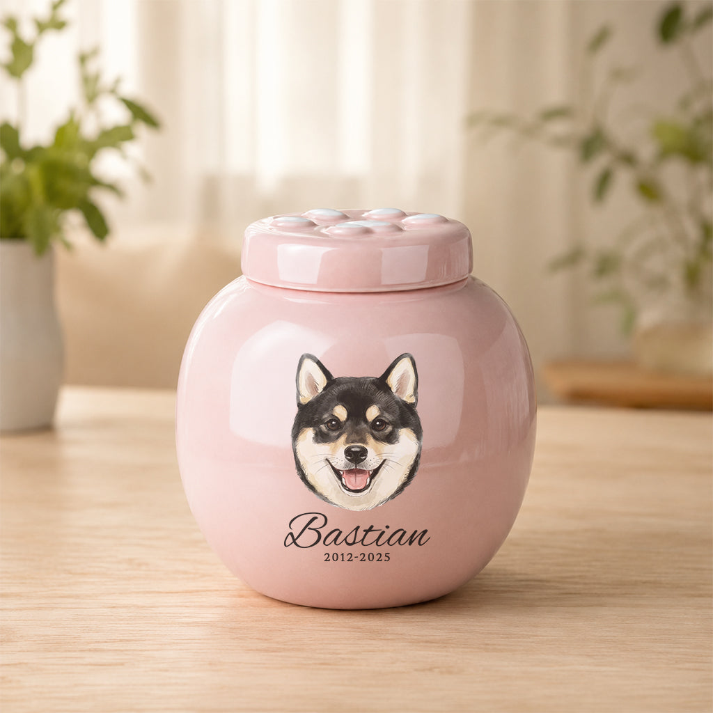 Soft pink ceramic dog cremation urn with paw print lid and personalized dog portrait on the front