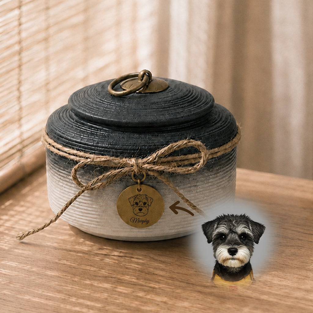 Close-up of engraved brass dog portrait charm tag attached to a ceramic memorial urn