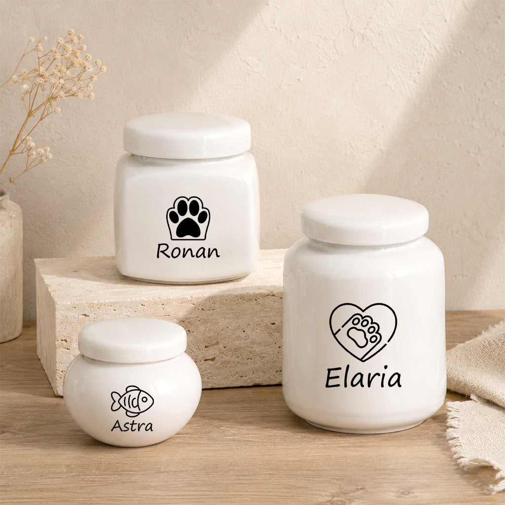 Four ceramic pet urn design options displayed side by side showing name engraving styles