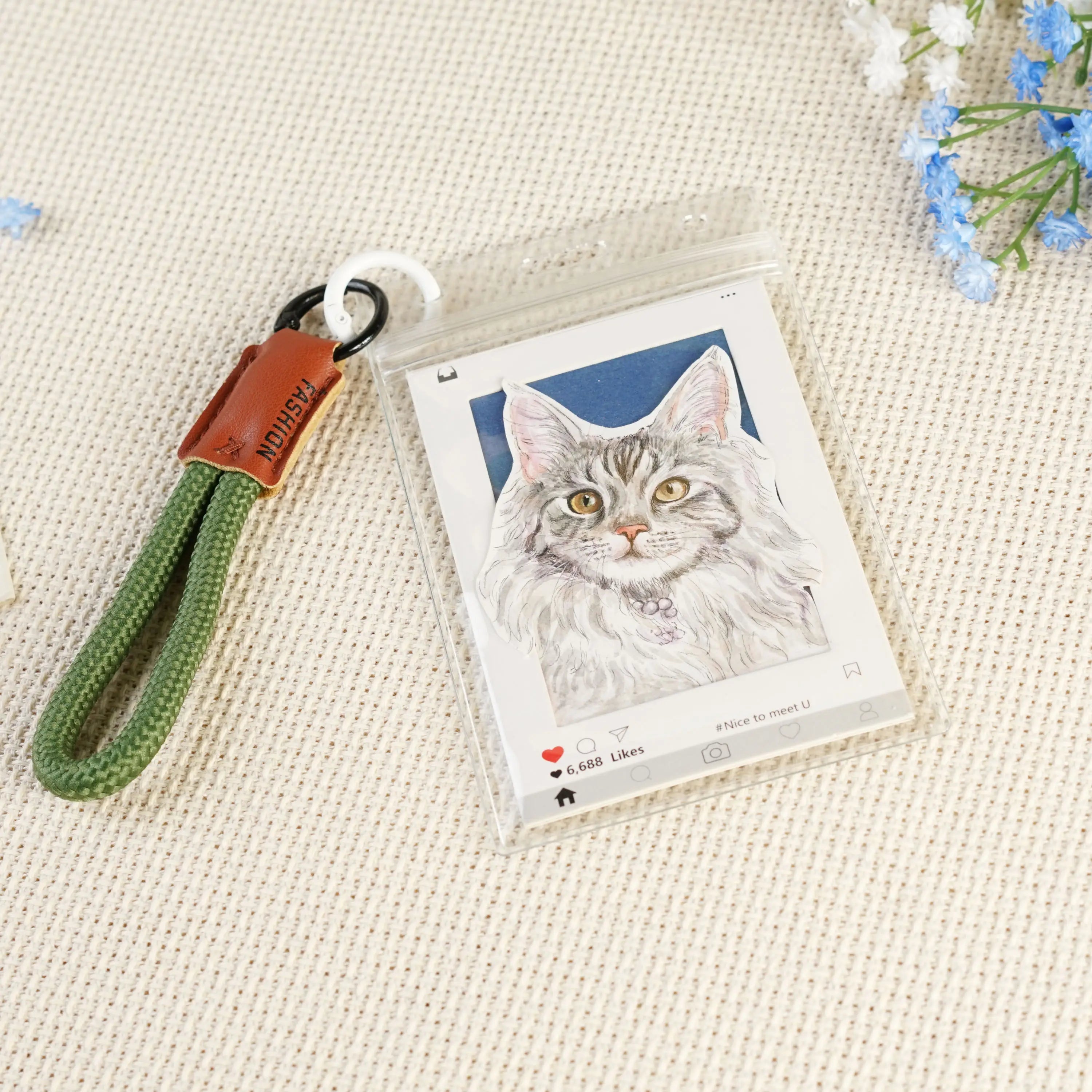 Custom cat portrait keychain with a green braided wrist strap and brown leather tab
